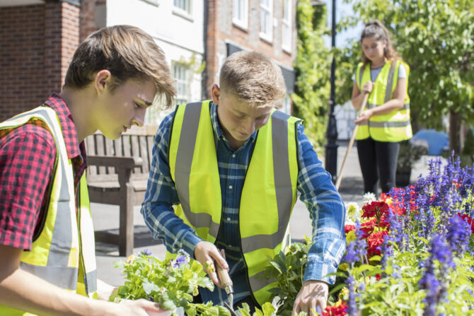 Group Of Helpful Teenagers Planting And Tidying Communal Flower Beds | Schools Week